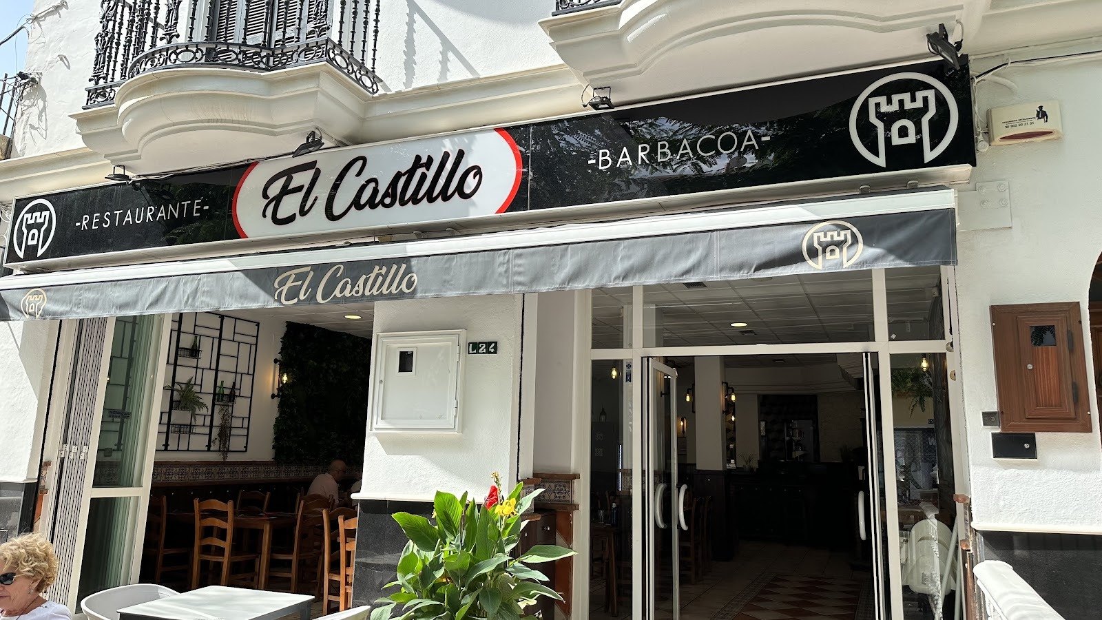 Fachada del Restaurante El Castillo con rótulo El Castillo y Barbacoa sobre el toldo